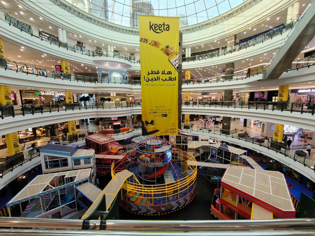 Huge interior of the City Center mall of Doha. Showing four floors with various shops and attractions.