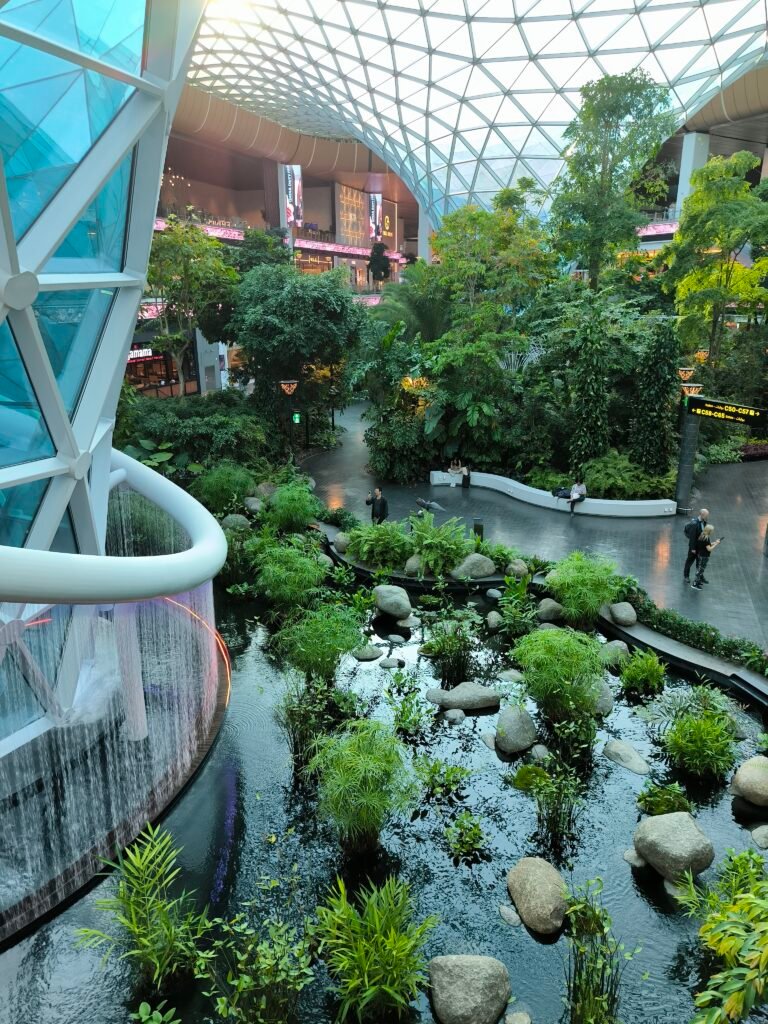 The Orchard at Hamad International Airport featuring a small waterfall and a lot of greenery.