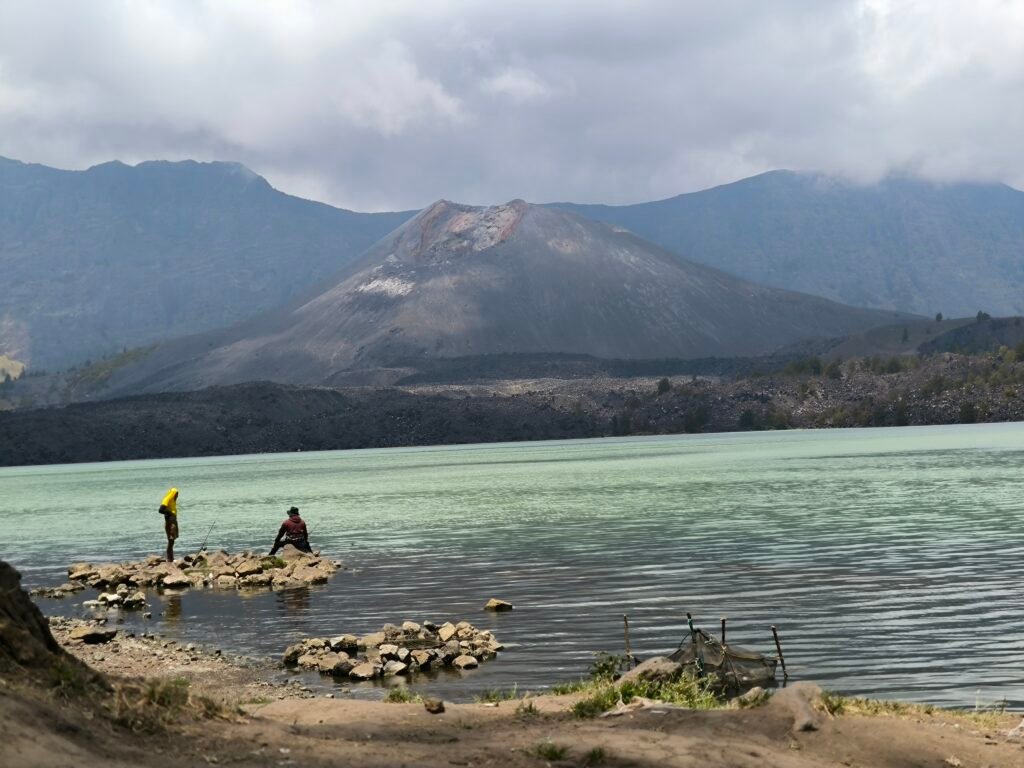Segara Anak: The sacred crater lake with a few fisherman and the crater rim towering around it.